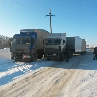 Два грузовика с крупногабаритными модулями на зимней дороге