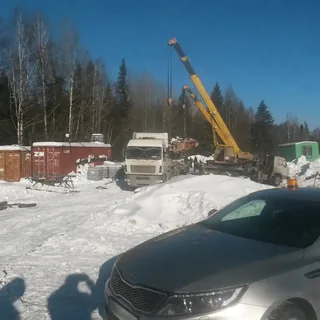 Погрузка секций башенного крана автокраном на зимней площадке