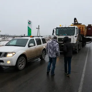 Перевозка гусеничной спецтехники на трале с автомобилем прикрытия зимой