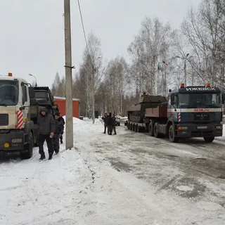 Два грузовика MAN при перевозке гусеничной техники на трале зимой