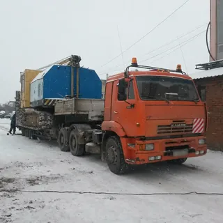 Перевозка гусеничной спецтехники на трале за тягачом КАМАЗ зимой
