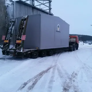 Перевозка модульного здания на трале по заснеженной промышленной площадке