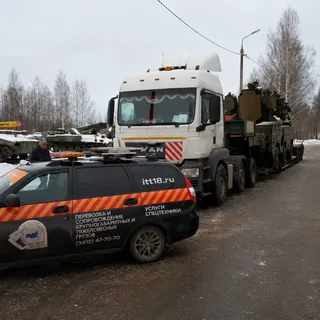 Автомобиль прикрытия сопровождает перевозку гусеничной техники на трале