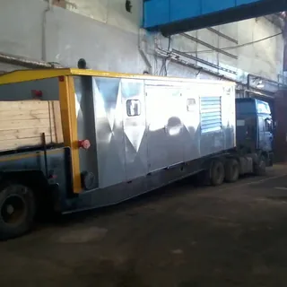 Перевозка крупногабаритного металлического модуля на бортовом грузовике в производственном цехе