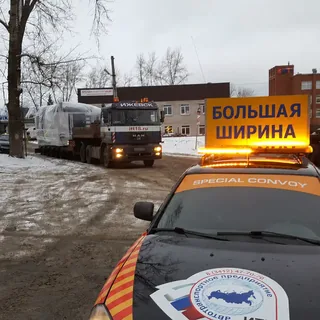 Автомобиль прикрытия сопровождает перевозку негабаритного груза на трале в Ижевске
